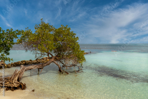 Boat on the seashore and stone spur. San Bernardo, Bolivar, Colombia.  photo