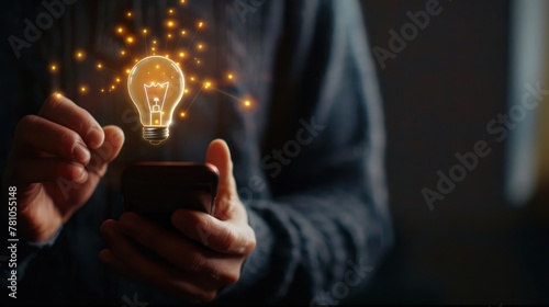 A person holding a smartphone with a virtual lightbulb emoji in a chat message, representing the exchange of ideas in virtual communication. 