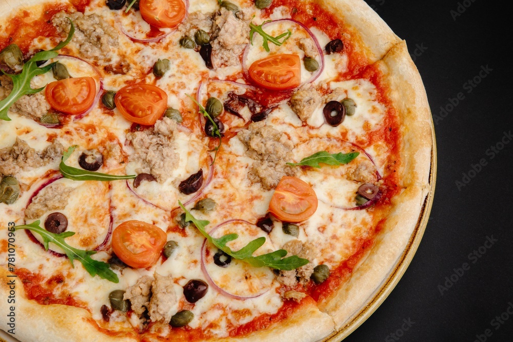 Delicious Pizza with Tuna, Tomatoes, Mozzarella Cheese, and Olives on Black Background Delicious Pizza with Tuna, Tomatoes, Mozzarella Cheese, and Olives on Black Background