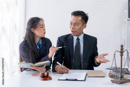 Lawyer engages with a smiling client during a legal consultation in a modern office. © amnaj
