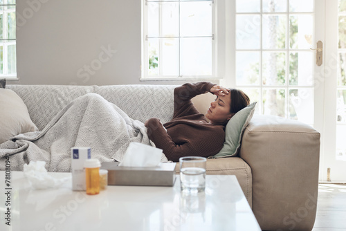 Woman, sick and headache with medication on sofa for flu, cold or sinus in living room at home. Tired female person with illness, fever or influenza in fatigue or asleep on couch from paracetamol photo