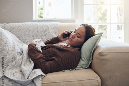 Sick woman, tissue and phone call with flu for help, advice or recovery on living room sofa at home. Tired female person talking on mobile smartphone with bacteria, fever or influenza in fatigue