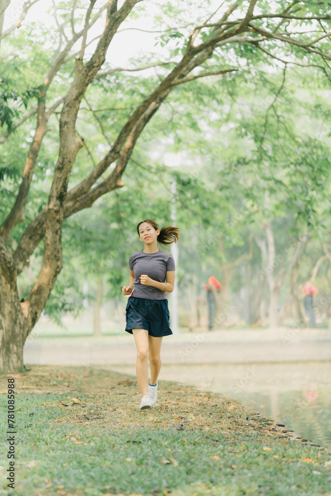 Asian woman stretching and warming up before going for a run at the park. Yoga, health care, weight loss exercise.