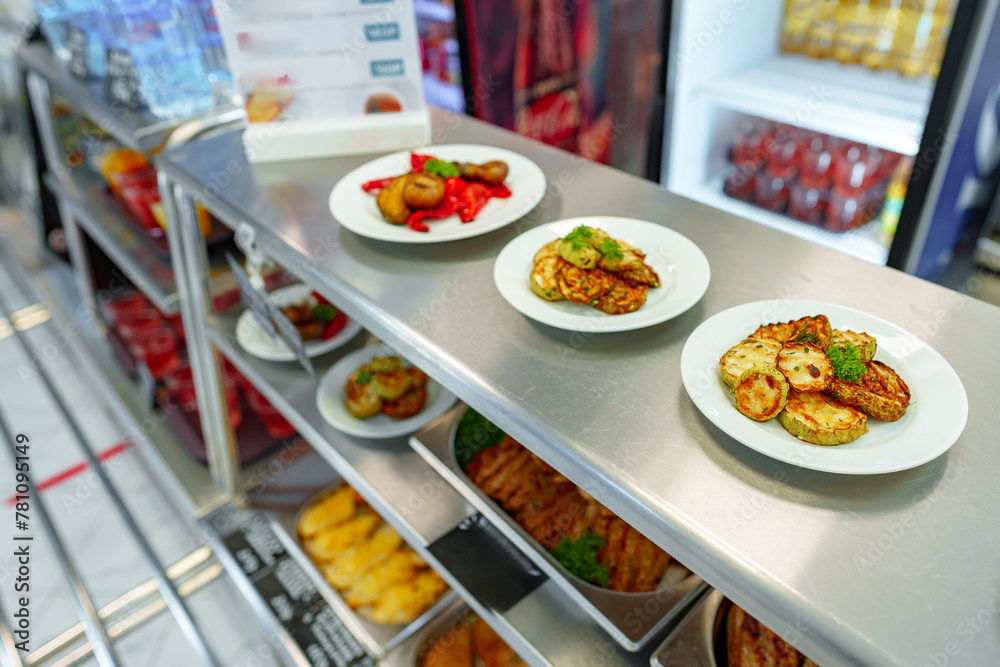 Assorted Gourmet Dishes Displayed on Shelves in a Modern Deli