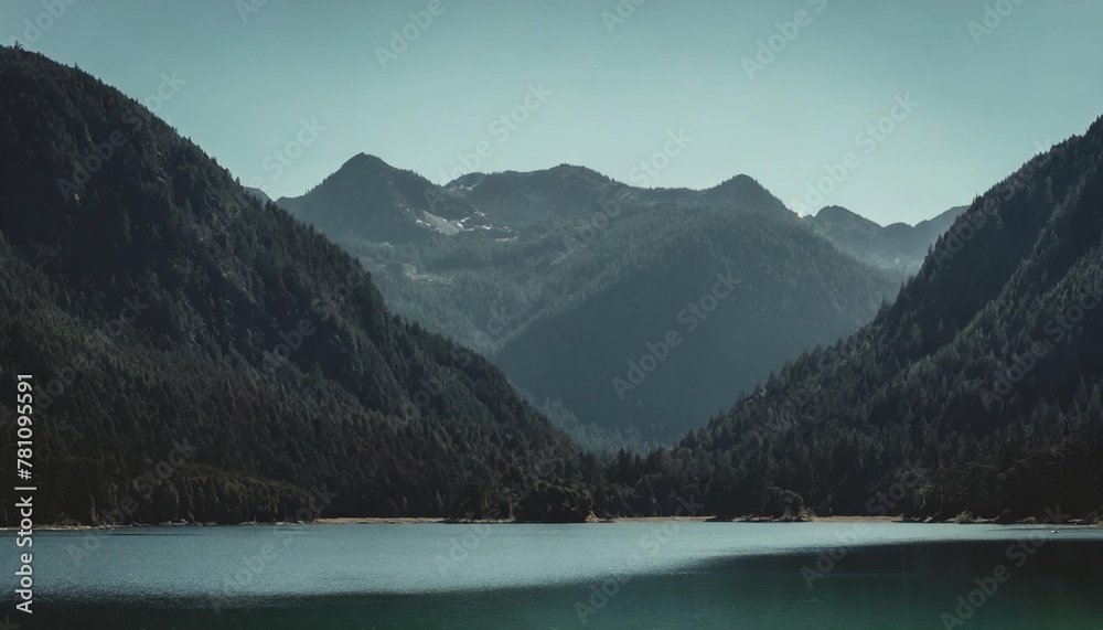 serene green lake nestled in the heart of towering mountains under a clear sunny sky
