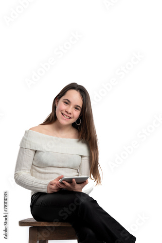 A woman is sitting on a wooden stool and holding a tablet