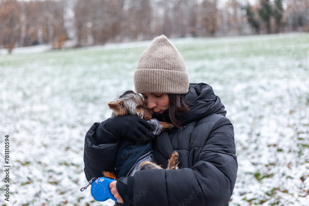Young woman with her little dog in the park in winter time. Young woman with her little dog in the park in winter time.