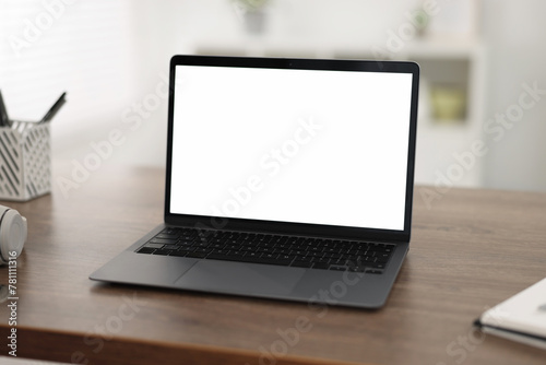 Laptop with blank screen on wooden table indoors, Space for text