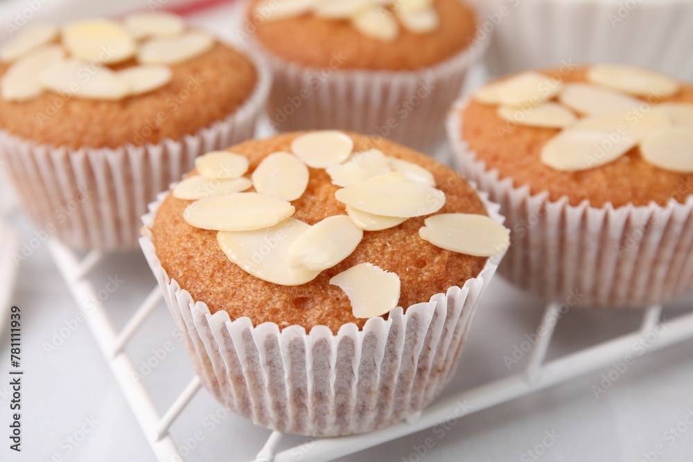 Muffins with fresh almond flakes on white table, closeup Muffins with fresh almond flakes on white table, closeup