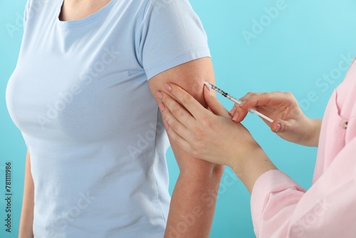 Diabetes. Woman getting insulin injection on light blue background, closeup