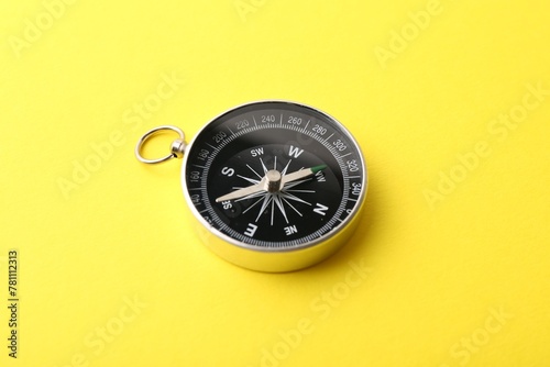 One compass on yellow background. Tourist equipment