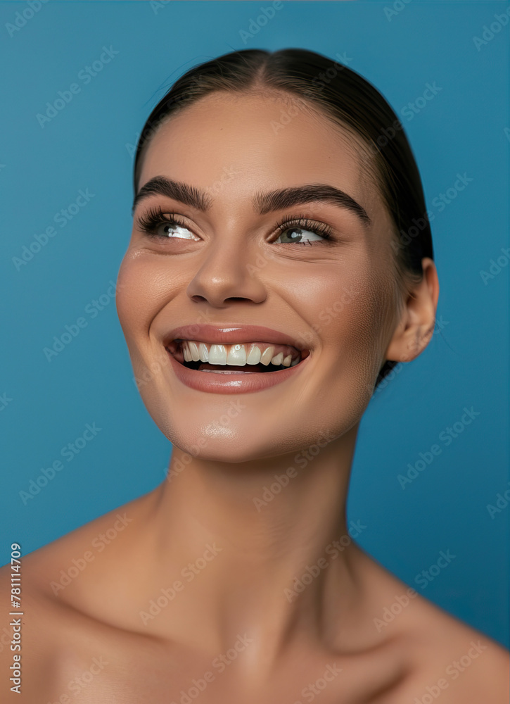 Portrait of a beautiful, smiling woman on a blue background
Portrait of a beautiful, smiling woman on a blue background