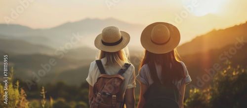 Adventure women in straw hats with backpacks, mountain sunset view, outdoor travel concept friends