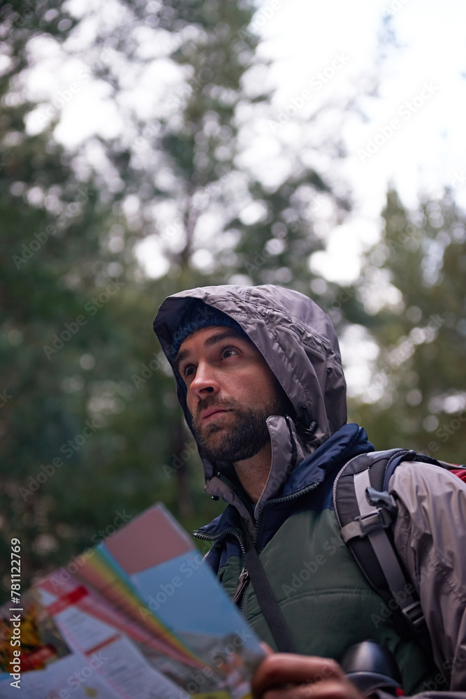 Search, forest and man with map for direction to camp in woods and thinking of adventure navigation. Confused, travel and lost in nature trekking with backpack and plan to location on hiking journey Search, forest and man with map for direction to camp in woods and thinking of adventure navigation. Confused, travel and lost in nature trekking with backpack and plan to location on hiking journey