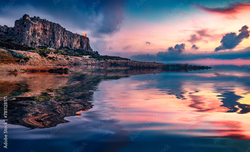 Huge cliff on San Vito cape reflected in the calm waters of Mediterranean sea. Majestic spring sunset on Sicily, Isolidda Beach location, Italy, Europe. Beauty of nature concept background.