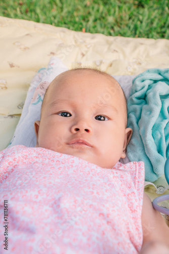 Infant Baby Girl is laying on her back in a pink bodysuit.