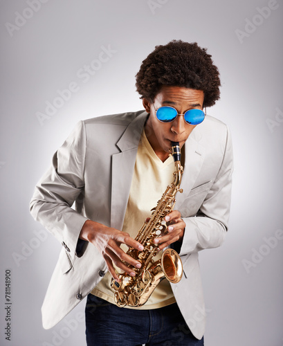 Photography Happy, black man and music, playing the saxophone with casual suit and sunglasses in studio