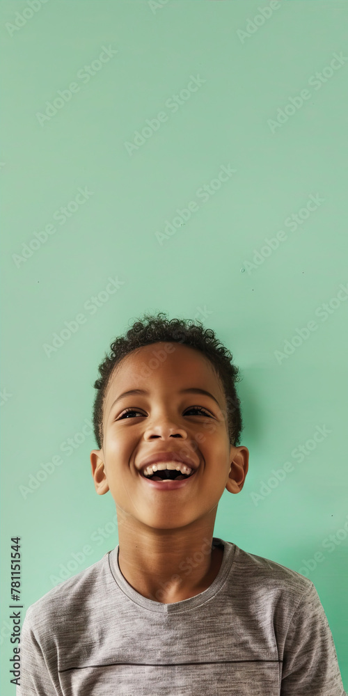 Smiling boy standing on mint background
Smiling boy standing on mint background