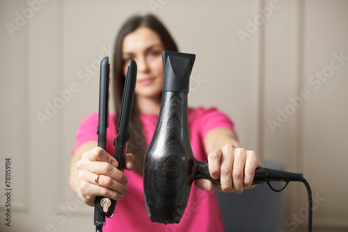 Woman showing and recommended a professional hair dryer and straightening iron
