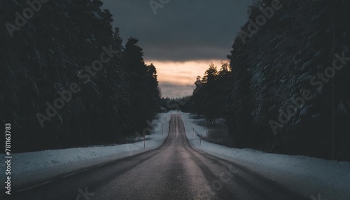 road leading towards colorful sunrise at winter in finland