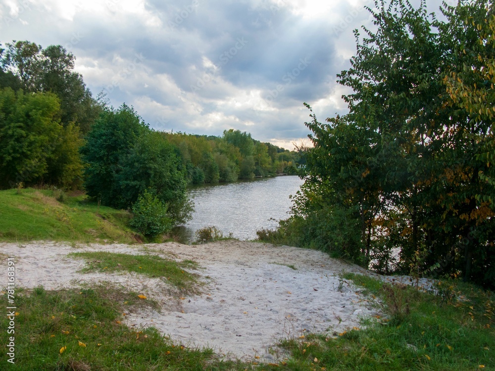 Beautiful shot of a lake surrounded by trees under a cloudy sky Beautiful shot of a lake surrounded by trees under a cloudy sky