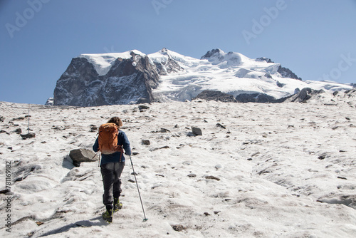 Lone Hiker Venturing Across a Snowy Glacier Landscape photo