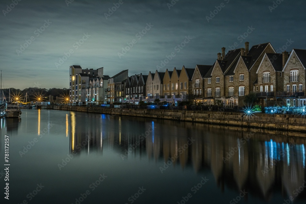 Night view of houses among the canal with light reflected in the water
