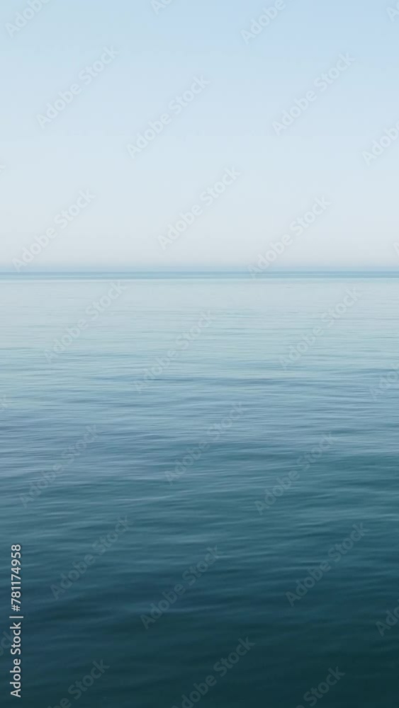 Vertical aerial view over calm sea water surface. Sun glare. Abstract nautical summer ocean nature. Holiday, vacation and travel concept. Nobody. Weather and climate change Vertical aerial view over calm sea water surface. Sun glare. Abstract nautical summer ocean nature. Holiday, vacation and travel concept. Nobody. Weather and climate change