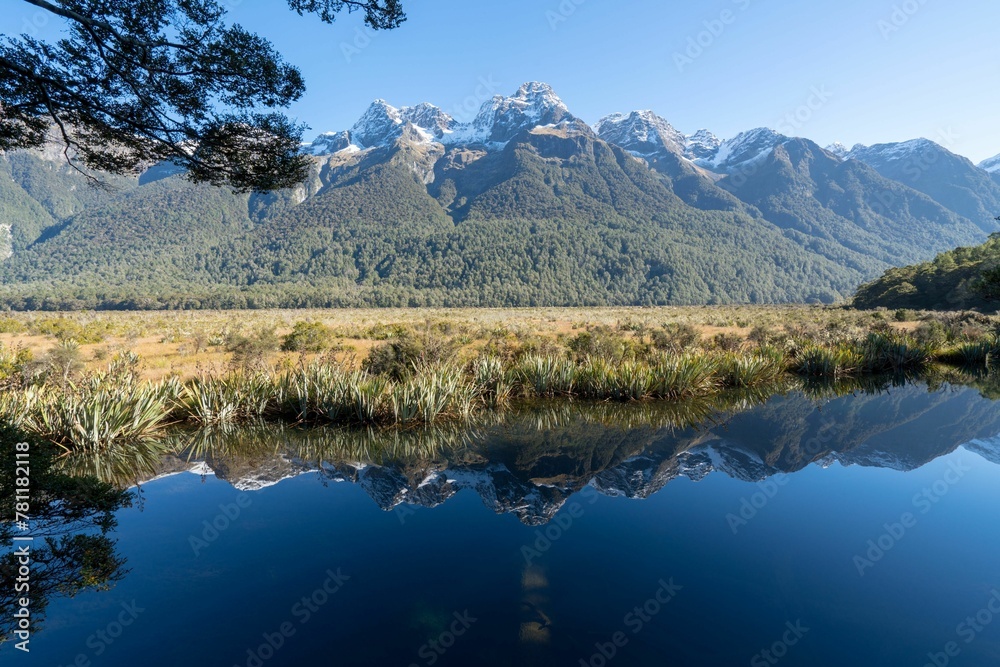 Beautiful landscape of a blue clear lake with dry grass lands in the Alps in New Zealand