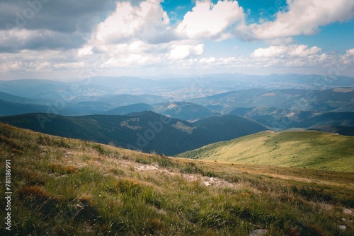 Beautiful view of the Carpathian Mountains in a grass valley with floating clouds above in Ukraine