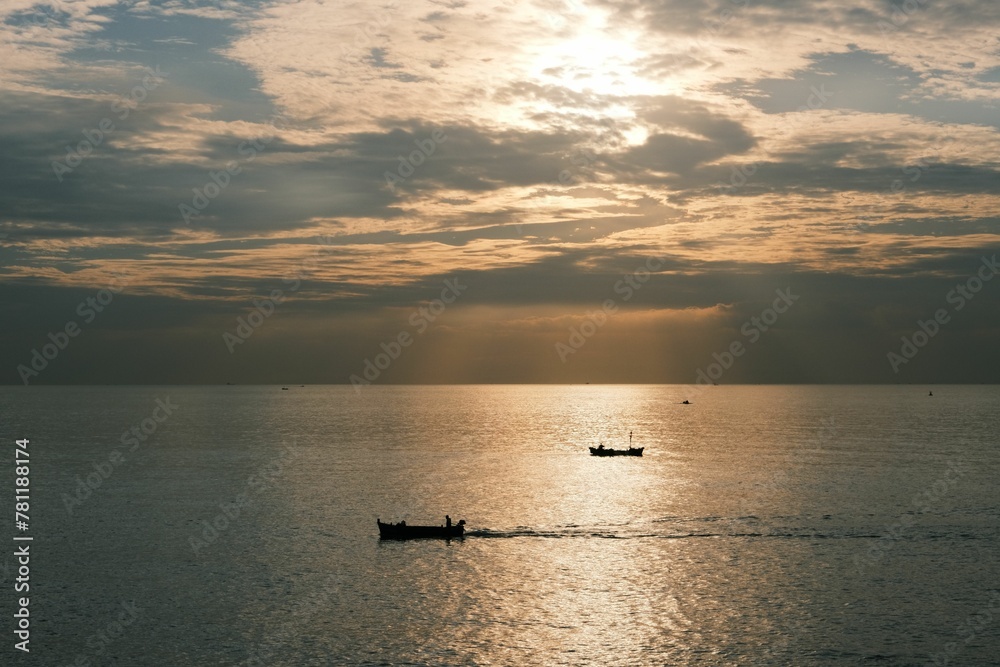 Beautiful landscape of the sea with the silhouette of boats on the sunrise