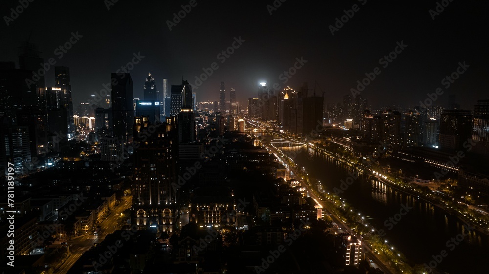 Gorgeous view of a modern city with a river surrounded by skyscrapers under glowing lights at night
