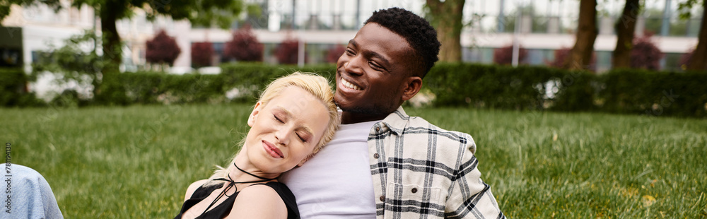 A multicultural couple, an African American man and a Caucasian woman, sitting serenely on a grassy field. A multicultural couple, an African American man and a Caucasian woman, sitting serenely on a grassy field.