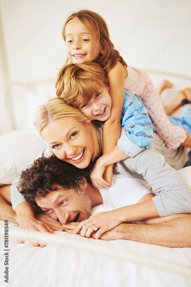 Portrait, happy and family on bed with kids, parents and play for bonding in bedroom. Couple, children and smiles for together, love and support in home on weekend for relaxing, break and happiness