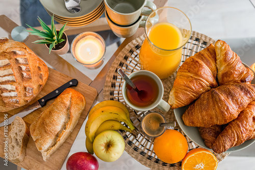 petit déjeuner délicieux vu de dessus composé de pain croissants fruits frais orange pommes et bananes thé et café photo