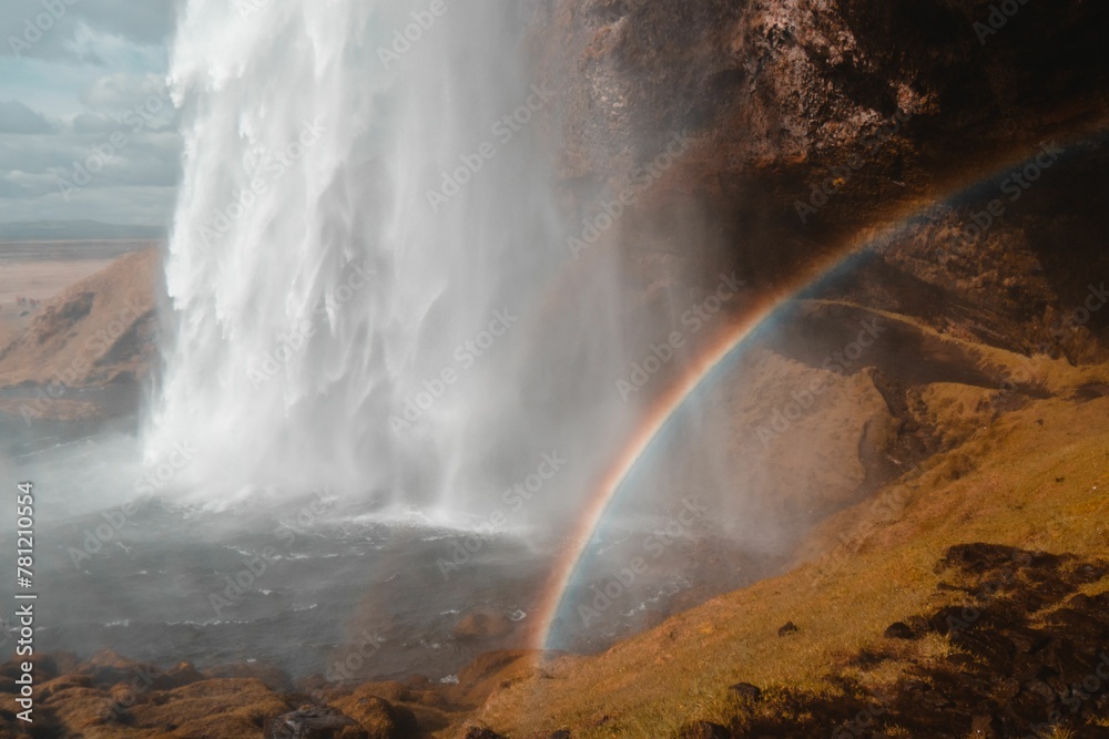 Low-angle shot of a beautiful waterfall with a rainbow in Iceland