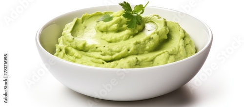 Guacamole in a white dish with a touch of parsley photo
