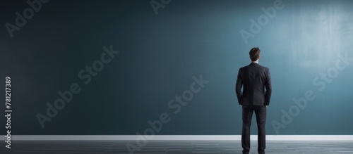 Man in Suit Facing Blue Wall