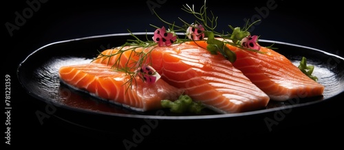 Fresh salmon pieces on dark plate with dill