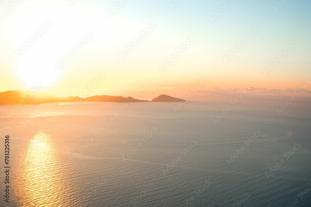 Obraz premium Aerial view of lake surrounded by hills during sunrise
