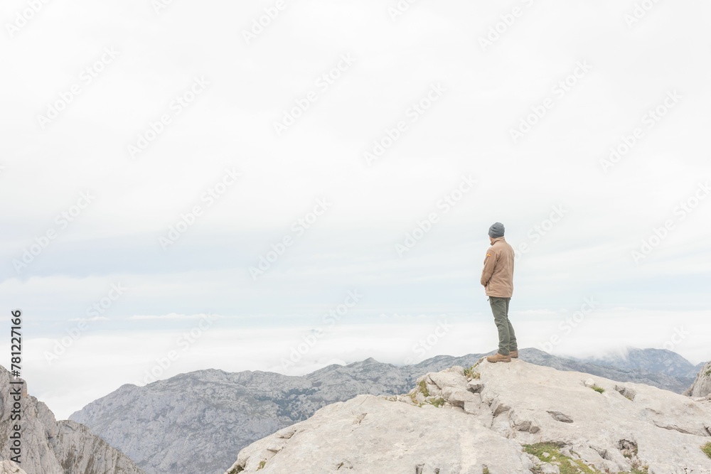 Hiker standing on the verge of a rocky mountain