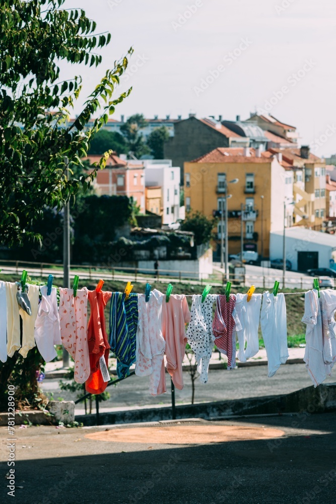 Vertical shot of a hanging laundry with neighborhood builings in the background