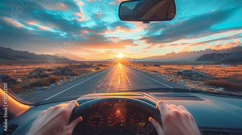 Driver's perspective on an open road journey towards a stunning sunset with mountain views. photo