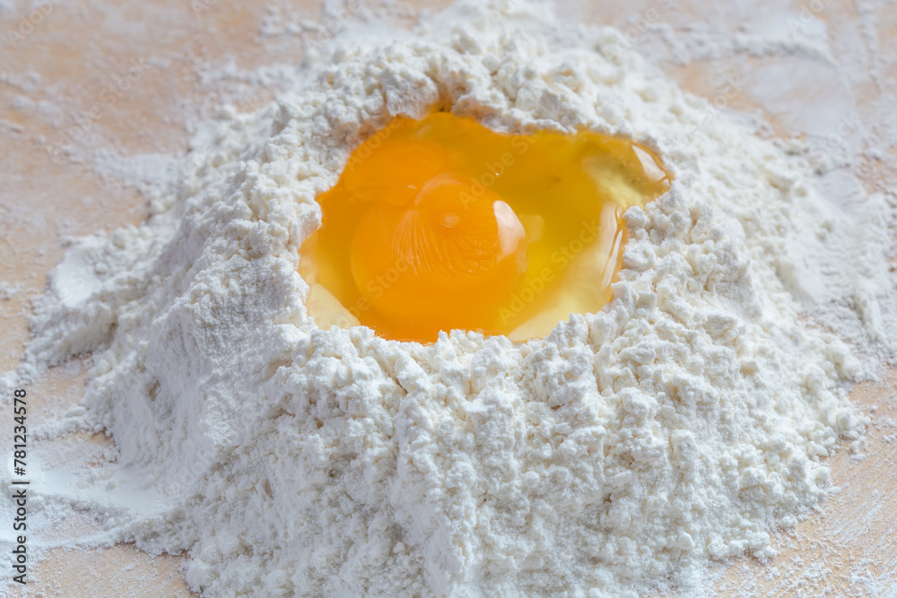 Broken egg on a heap of wheat flour close-up Broken egg on a heap of wheat flour close-up