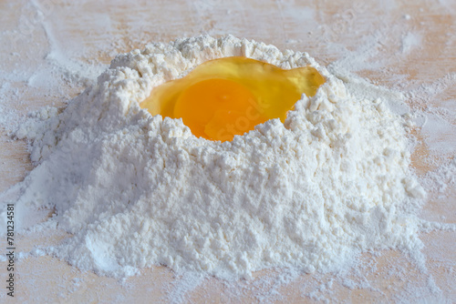 Broken egg on a heap of wheat flour close-up