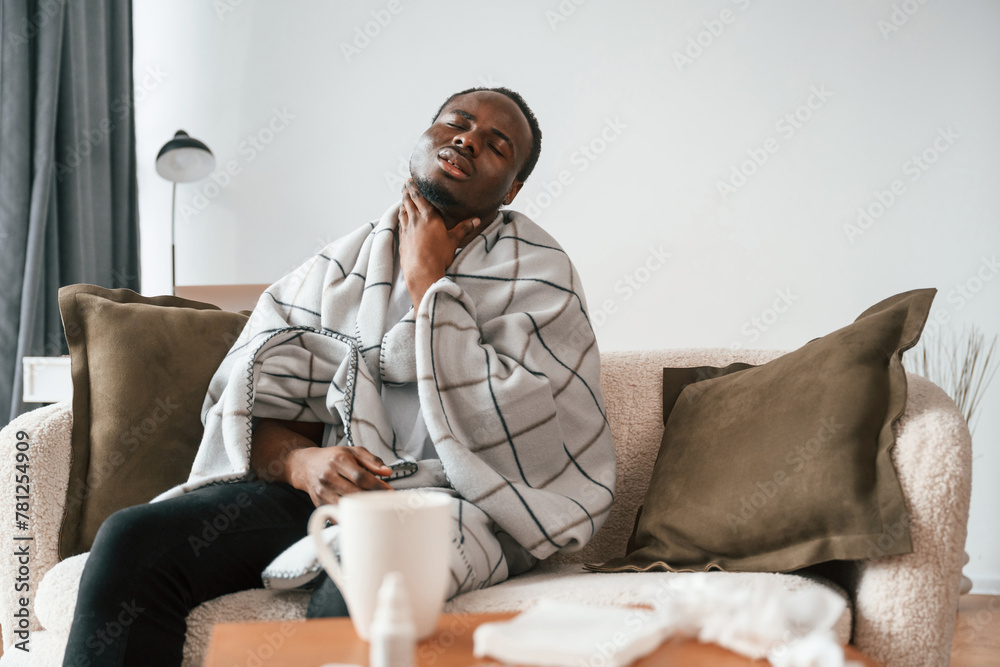 Pain in the throat. Sick black man is at home