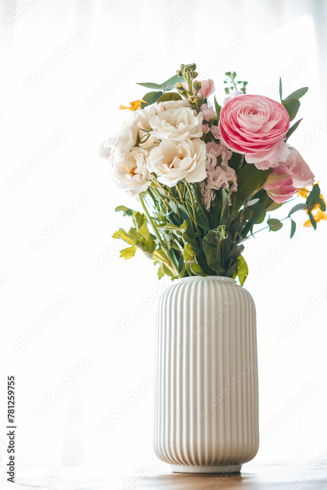 Obraz premium A colorful bouquet of flowers in various shapes and sizes graces a ribbed white vase