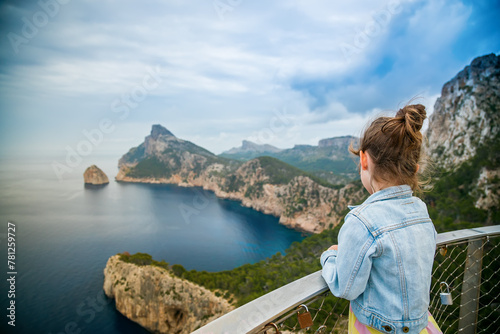 Back view of a little girl watching a beautiful view to the cape Formentor from Mirador de El Colomer in Mallorca