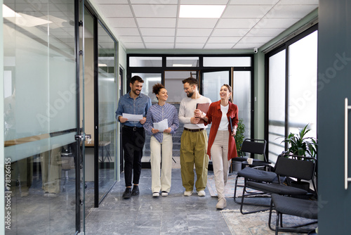 Business people talking and walking through office building 