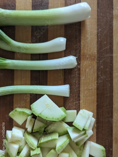 sliced zucchini and green onion on a chopping board